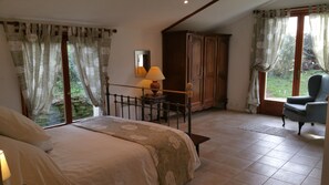 Une chambre à coucher avec un lit, une table de chevet avec une lampe, une armoire et une chaise.