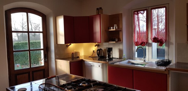 A kitchen with a gas stove, a coffee maker, and a sink. - Private heated pool,share with friend and family, full aircon secluded location. (Breuil-Barret)