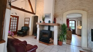 Ein geräumiges Wohnzimmer mit Kamin, Ledersofas und einer Steinwand.