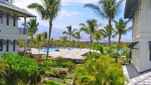 A resort with multiple buildings, a pool, and lush greenery.