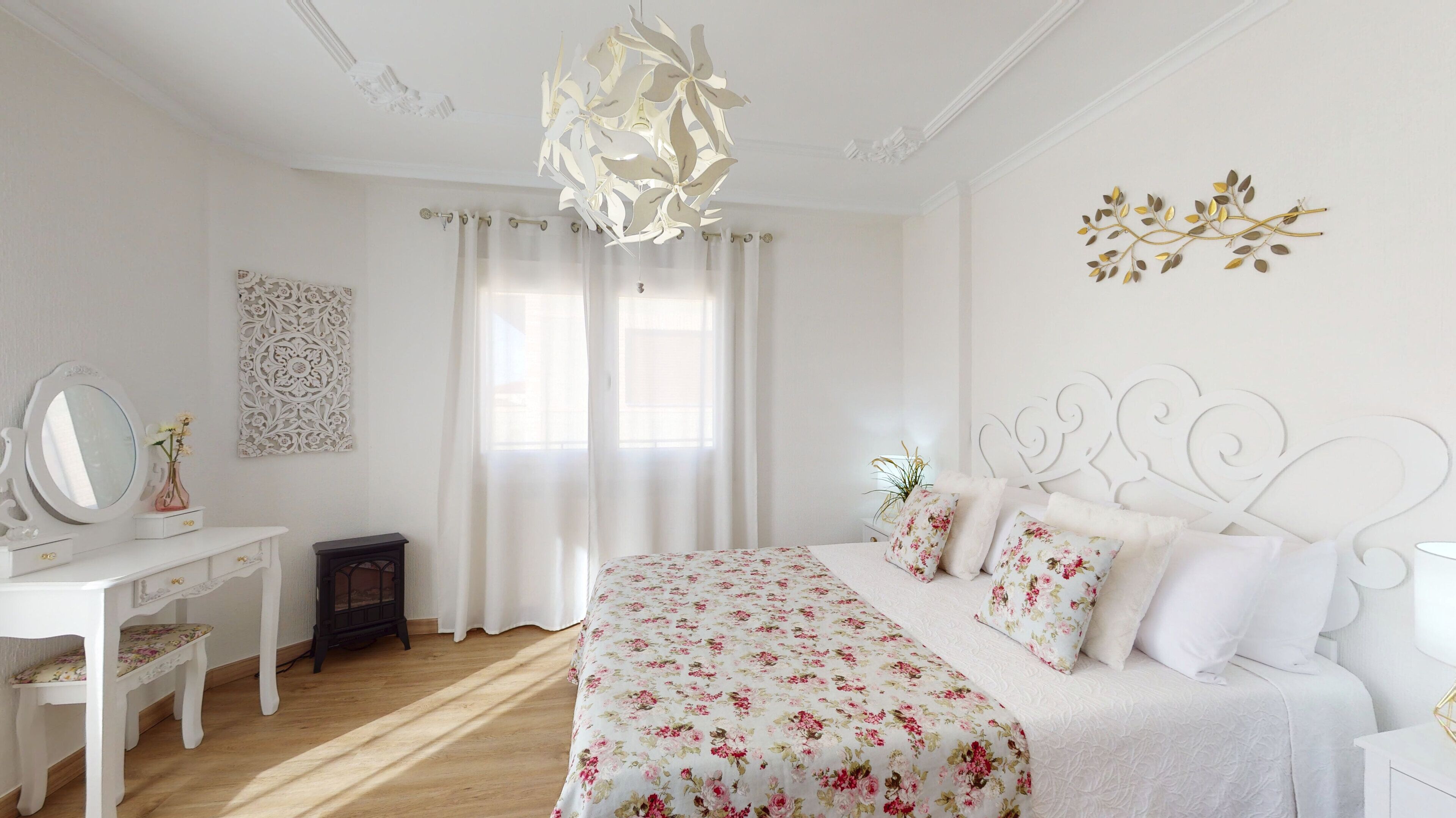 Un dormitorio con cama, cómoda, espejo y un adorno en la pared.