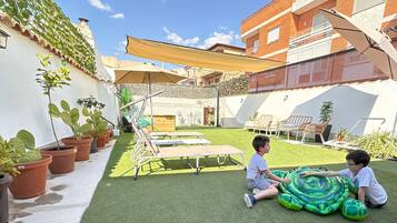 Relax in style on this patio, complete with comfortable lounge chairs and a shaded area.