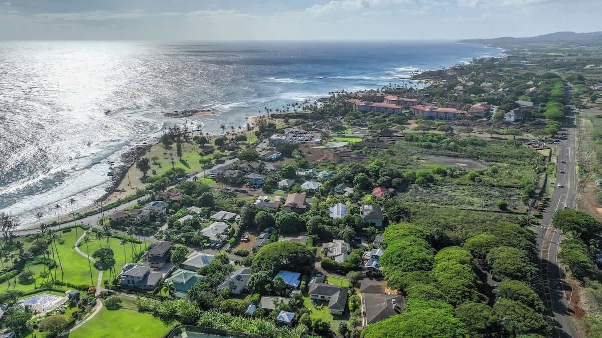 A coastal residential area with houses, roads, and a beach.