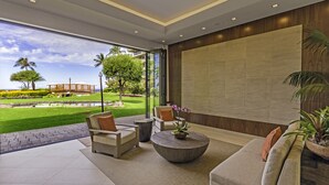 Un salon moderne avec une grande fenêtre, deux fauteuils, une table basse et un canapé.