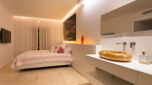 A modern bedroom with a bed, a bedside table, a mirror, and a bathroom with a toilet and sink. - BEAUTIFUL VILLA IN THE HEART OF Playa den Bossa<br>ETV-2047-E (Playa den bossa, San jordi de ses Salines, IBIZA)