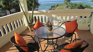 A patio with a round glass table, two chairs, and a potted plant. - Golden Rod Villa, a fabulous establishment typical of the island mauritius! (flacq)