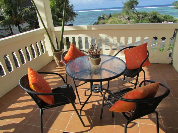 A patio with a round glass table, two chairs, and a potted plant. - Golden Rod Villa, a fabulous establishment typical of the island mauritius! (flacq)