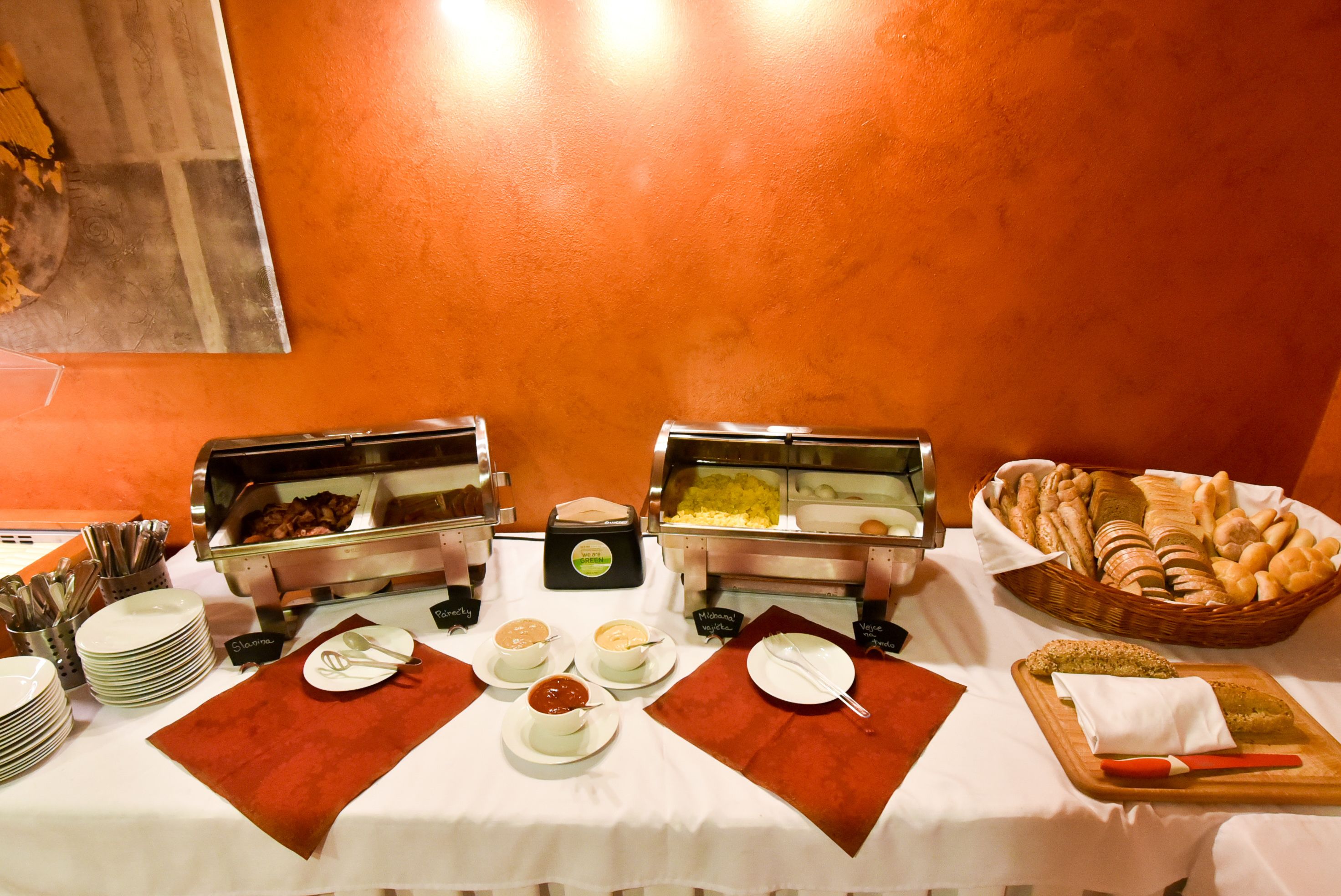 A buffet table with various food items and utensils.