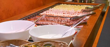 A buffet with various food items and serving utensils.