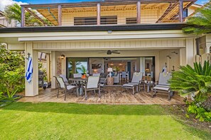 Eine überdachte Terrasse mit Gartenmöbeln, einem Grill und Blick ins Haus.