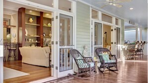 A spacious living area with a sofa, wicker chairs, and a dining table. - **THE ROYAL COMPOUND @ THE ANNEX** Pool + Last Key White Glove Service... (Key West)