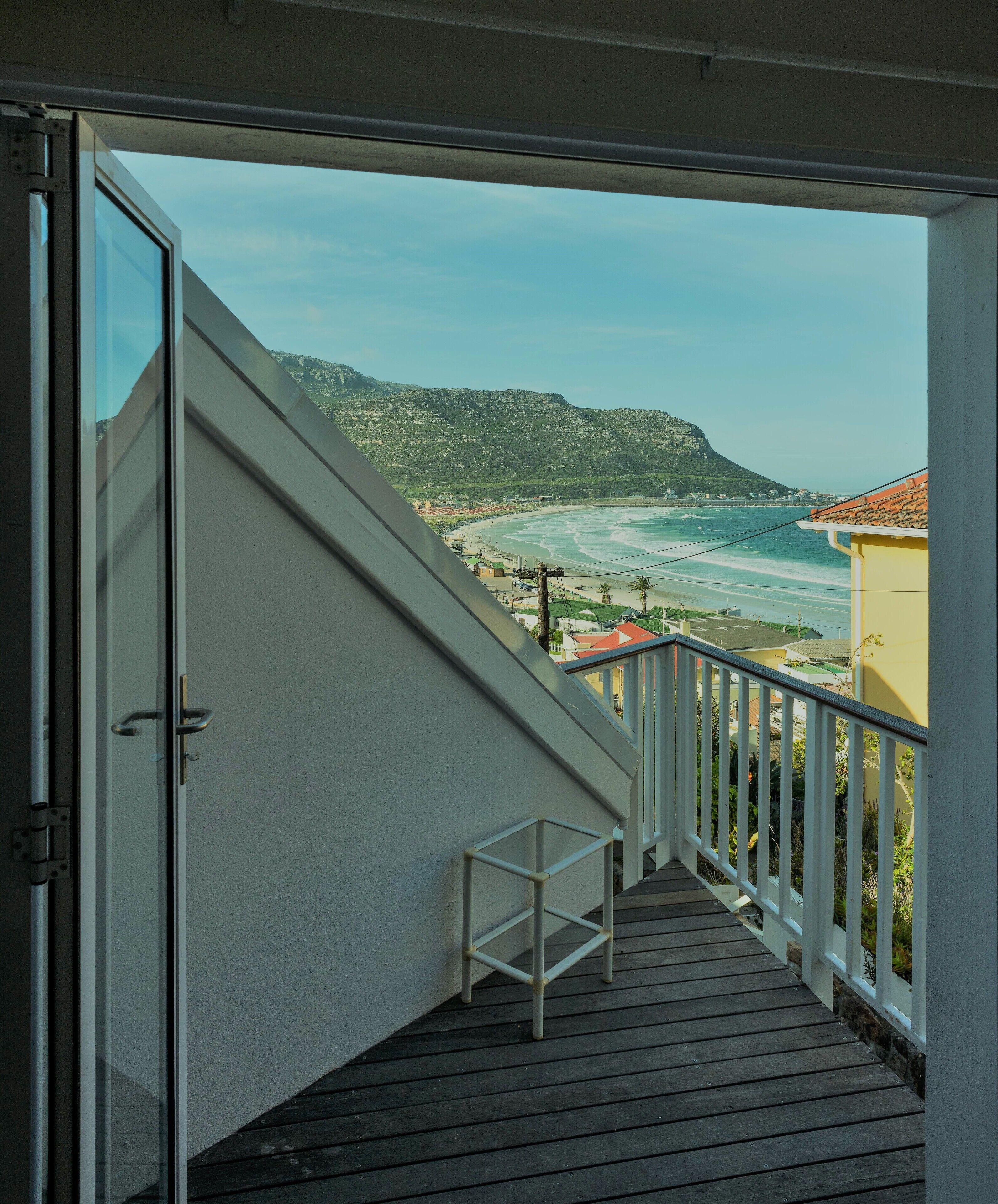 Un balcón con vista a la playa y las montañas.