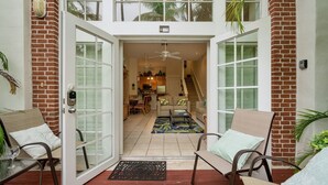 A spacious entryway with a glass door leading to a living area, a dining area, and a kitchen.