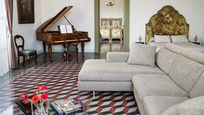 A room with a grand piano, a sofa, a bed, and a patterned floor. - Don Giovanni charming apartment (Catania)