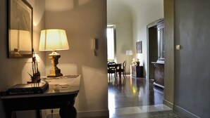 A hallway with a table lamp, a framed map, and a ship model. - Don Giovanni charming apartment (Catania)