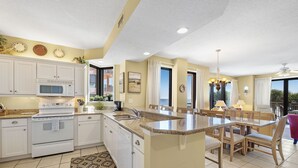 A modern kitchen with white cabinets, a microwave, an oven, and a dishwasher. - 201C Beautiful Beachfront Condo (Orange Beach)
