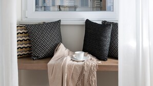 A cozy seating area with a window view of a building, a cup, and a patterned cushion. - Charme 308 (Rome)