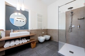 Panorama driepersoonskamer | Badkamer | Een douche, gratis toiletartikelen, een haardroger, pantoffels