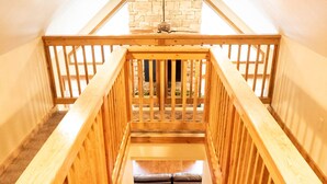 Eine Holztreppe mit einer Steinwand oben.