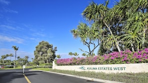 Una strada che conduce a un cancello con un cartello che indica 'Kuilima Estates West'.