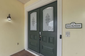 Uma porta dupla com painéis de vidro decorativos e uma placa acima.