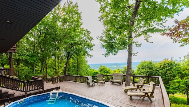 A wooden deck with a swimming pool, outdoor furniture, and a view of the landscape. - Laurel View Retreat - Spacious Private Estate Experience (Hopwood)