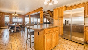 A spacious kitchen with wooden cabinets, a large island, and a stainless steel refrigerator. - Laurel View Retreat - Spacious Private Estate Experience (Hopwood)