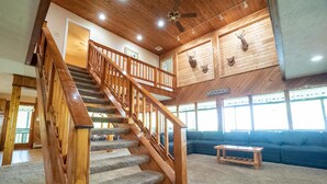 A wooden staircase with carpeted steps leading to a second floor. A wooden bench is placed in the living area, and a 'Welcome' sign is visible on the wall. - Laurel View Retreat - Spacious Private Estate Experience (Hopwood)