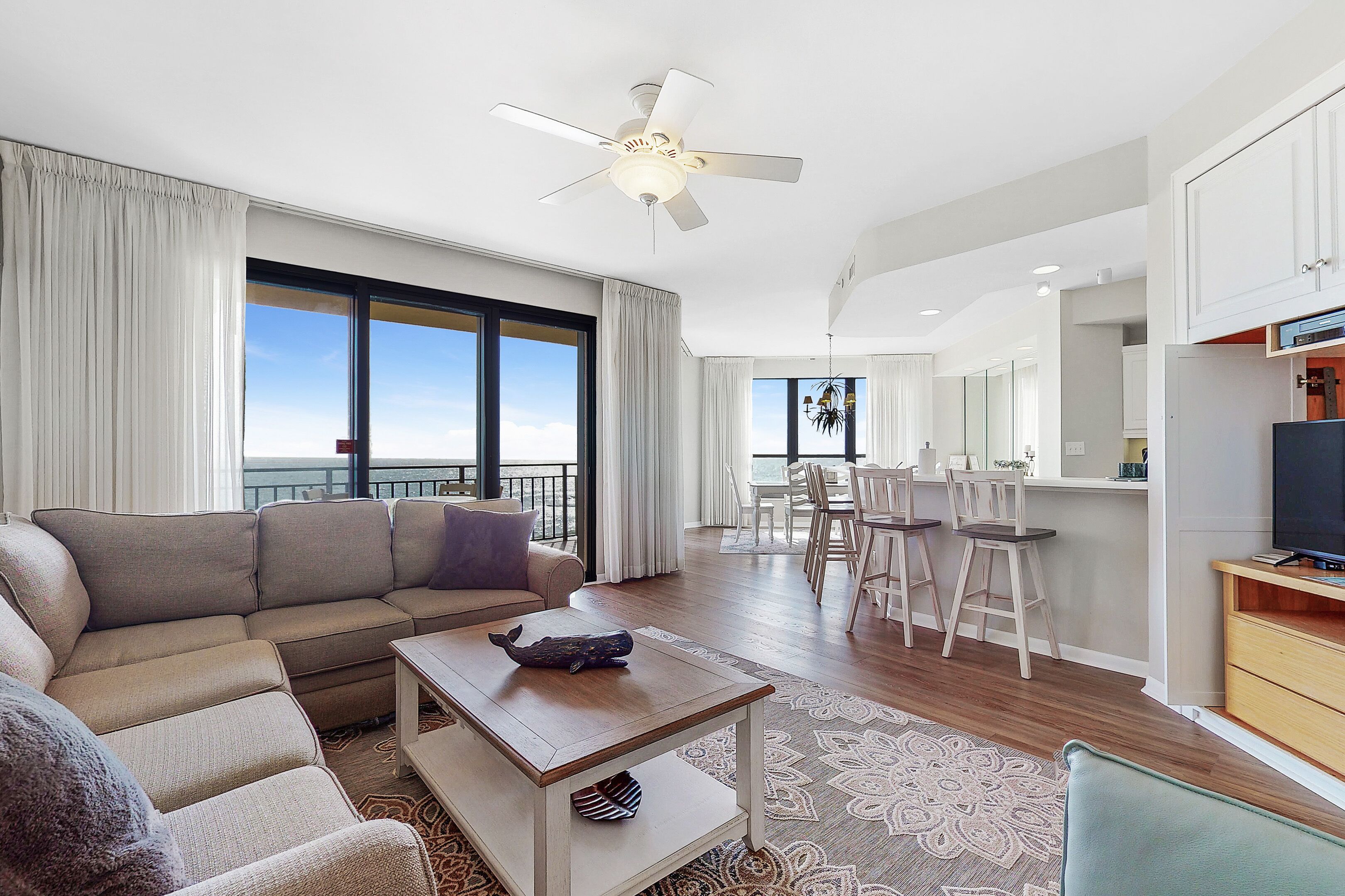 A modern living room with a sofa, coffee table, and a dining area with chairs and a table.