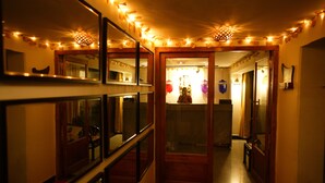 Corredor com espelhos, luzes de fada e uma porta que dá para outro quarto.