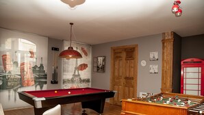 A pool table with a red felt surface, a foosball table, and a billiards cue rack. - Authentic attic in the center of Béjar (Béjar)