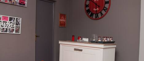 A room with a red clock, a white cabinet, and a red bean bag chair.