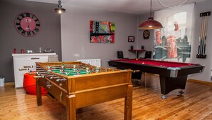 A room with a foosball table, pool table, and a clock on the wall. - Authentic attic in the center of Béjar (Béjar)