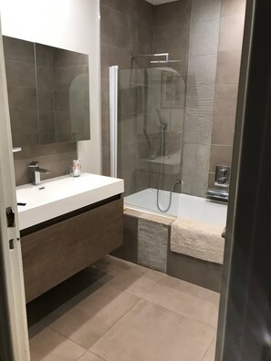 Bathtub, hair dryer, towels, toilet paper