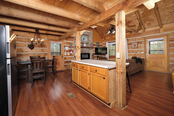 L’intérieur d’une cabane en rondins comprend une cuisine, un coin repas et un salon.