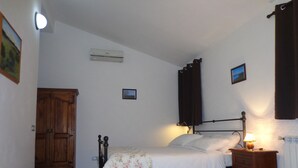 Ein Schlafzimmer mit Bett, Nachttisch, Lampe und einem Holzschrank.