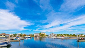 A marina with boats docked, a clear blue sky, and buildings in the background. - 3250 - Peace at Sea-Little Harbor Beach Resort - Tampa Bay (Ruskin)