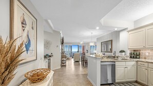 A spacious kitchen with a central island, white cabinetry, and a view to the living area. - 604W - Beachfront condo with Amazing views! (Orange Beach)
