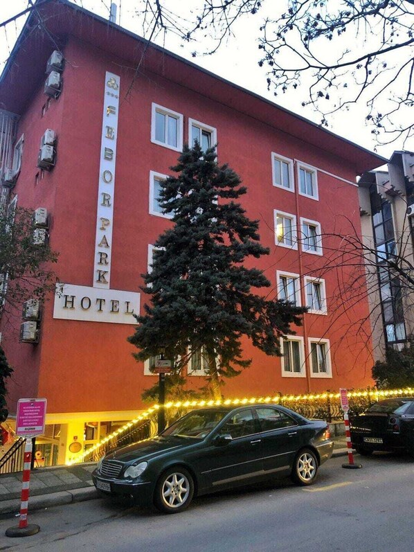 A red building with a sign that reads "BOROPARK HOTEL".