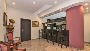 Un vestíbulo con zona de bar, asientos y una puerta.