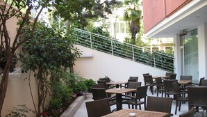 Un patio al aire libre con muebles de mimbre y una escalera que conduce a un nivel superior.