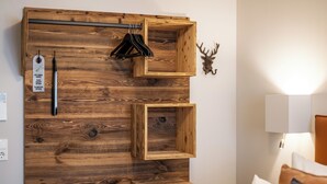 A room with a wooden wall panel, a coat rack, a lamp, and a deer head decoration. - Hotel Goldene Steig (Kempten)