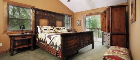 A bedroom with a wooden bed, a nightstand, a bench, and a ceiling fan.