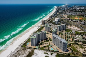 An aerial view of a coastal area with high-rise buildings, a beach, and a sports complex. - Beachfront Luxury @ Gulf Views, Large Deck, Pools, Beach Bar ~ 2 Master Bedrooms ~ Silver Shells (Destin)