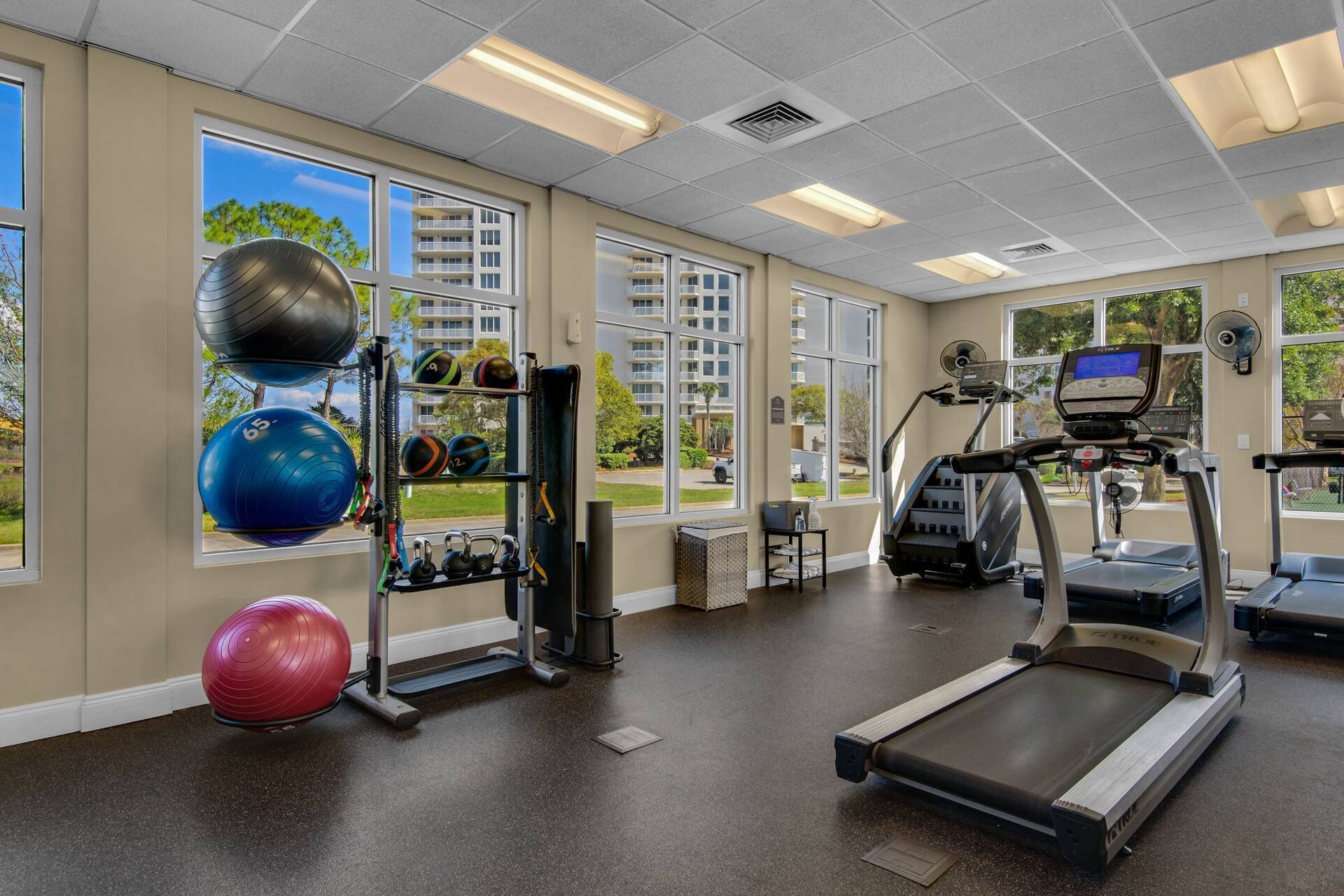 A gym with treadmills, exercise balls, and weights.