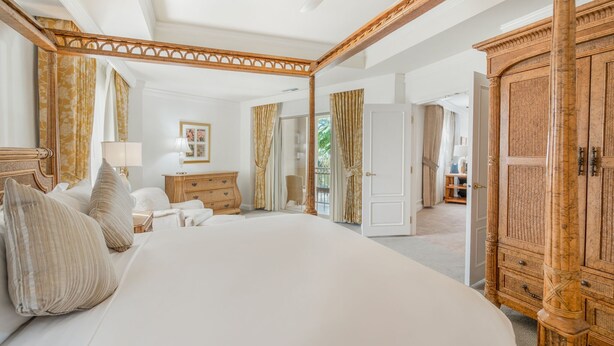 Quarto espaçoso com uma cama grande, guarda-roupa de madeira e vista para o exterior.