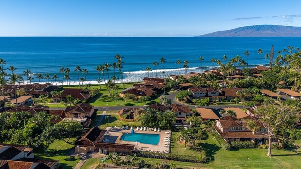 A coastal residential area with houses, a swimming pool, and a view of the ocean.