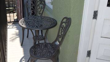 Bistro set on the balcony offers a cozy nook for coffee in the morning or cocktails as you overlook the Picayune Alley