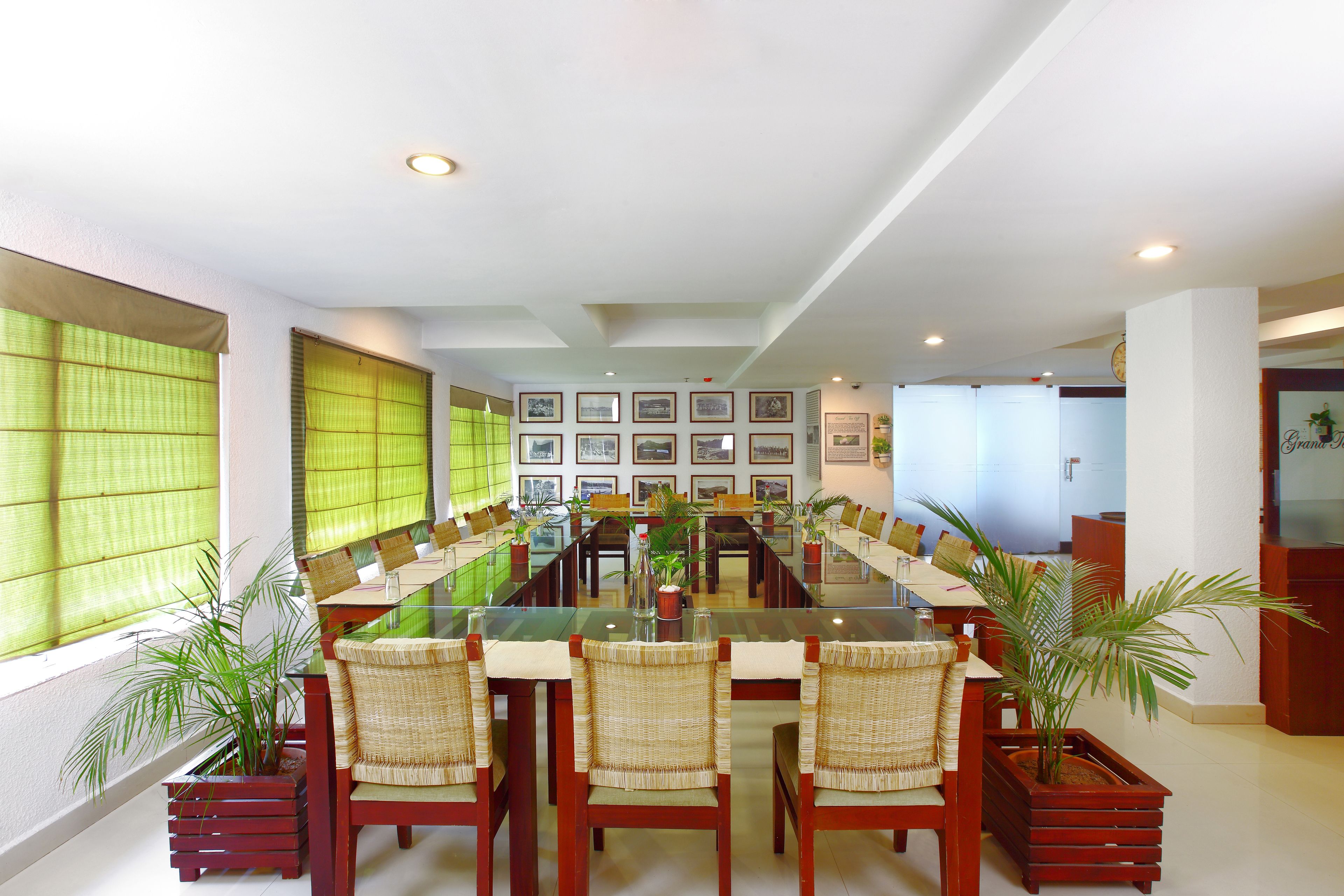 A conference room with a long table, chairs, and potted plants.