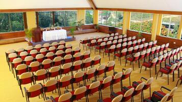 Une grande salle où de nombreuses rangées de chaises sont disposées pour un événement.